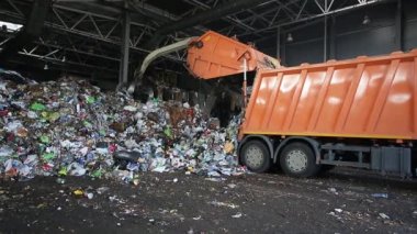 Grodno, Belarus - Ekim 2019: kazıcı modern atık geri dönüşüm tesisinde çöp yığını oluşturuyor. Çöp toplama ve ayıklama. Atıkların geri dönüşümü ve depolanması