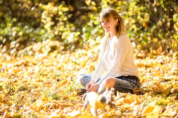 Meisje zit en ontspannen op de grond in de herfst bos met koffie — Stockfoto