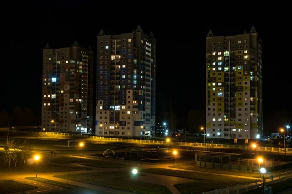 Panorama nocturno de Luz en las ventanas de un edificio de varios pisos . — Foto de Stock