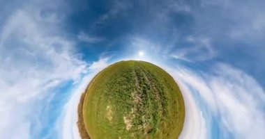 Uzayın kıvrımlı küçük bir gezegen dönüşümü. Bulutlu bir günde tarlalar arasında tam uçuş panoramasının soyut bükülmesi ve dönüşü.