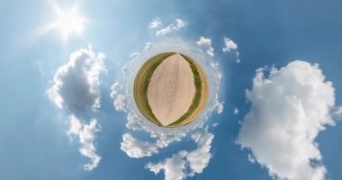 Uzayın kıvrımlı küçük bir gezegen dönüşümü. Bulutlu bir günde çakıllı yolda, tarlalarda soyut bükülme ve tam uçuş panoramasının dönmesi.