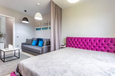 Minsk, Belarus - Eylül 2019: Stüdyo dairelerde çift kişilik yatak odası, kanepe ve mavi yastıklar