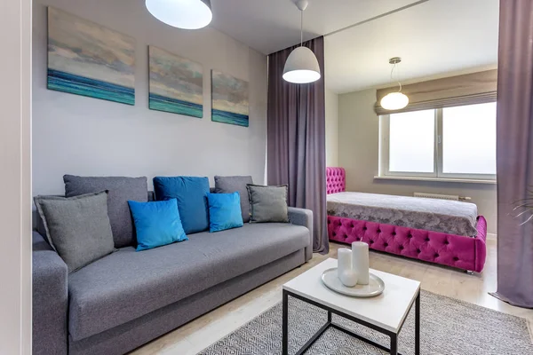 MINSK, BELARUS - SEPTIEMBRE, 2019: Interior del dormitorio moderno en apartamentos tipo estudio con cama de matrimonio, sofá y almohadas azules —  Fotos de Stock