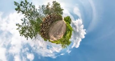 Uzayın kıvrımlı küçük bir gezegen dönüşümü. Bulutlu bir günde çakıllı yolda, tarlalarda soyut bükülme ve tam uçuş panoramasının dönmesi.