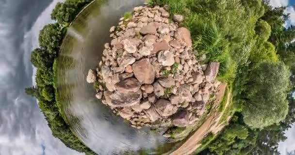 Courbure de l'espace de petite transformation planétaire. Torsion abstraite et rotation du paysage panoramique de plein vol sur le rivage de pierre près de la rivière par temps ensoleillé avec des nuages impressionnants .