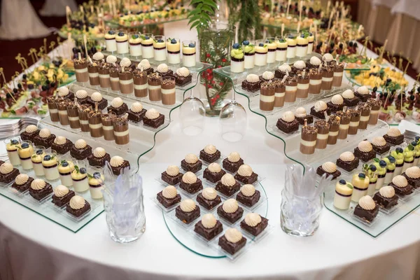 Catering. Off-site food. Buffet table with various sweet chocolate canapes, sandwiches and snacks with curd, strawberries, cheese and mint Royalty Free Stock Photos