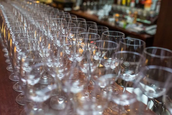 Banyak gelas kosong di meja pesta resepsi. Menutup di baris kacamata mempersiapkan diri untuk layanan untuk pesta makan malam — Stok Foto