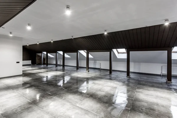 Üres bútorozatlan tetőtéri manzárd szoba belső tér fa oszlopok és nedves beton padló tetőszinten fekete és ki stílus színe — Stock Fotó