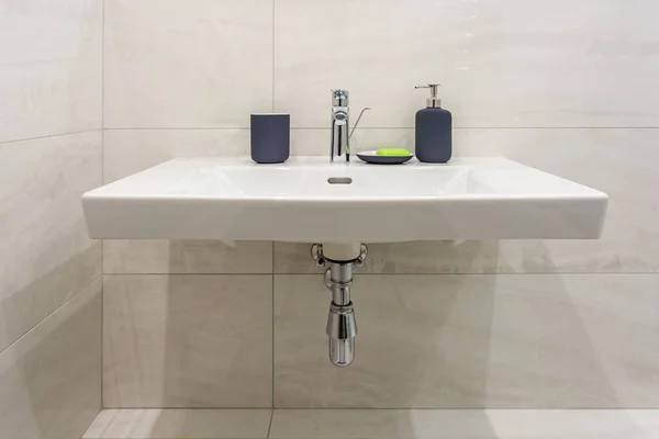 Soap and shampoo dispensers near Ceramic Water tap sink with faucet in expensive loft bathroom or kitchen