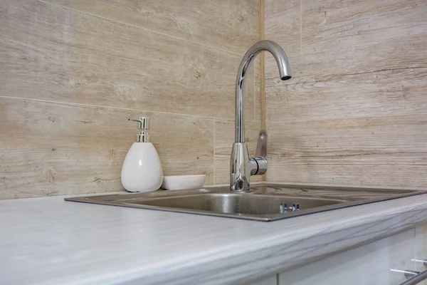Мыло и шампунь диспенсеры рядом с керамической водопроводной раковиной с краном в дорогой лофт ванной или кухней — стоковое фото