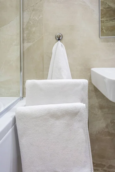 Белые полотенца на вешалке в ванной комнате — стоковое фото