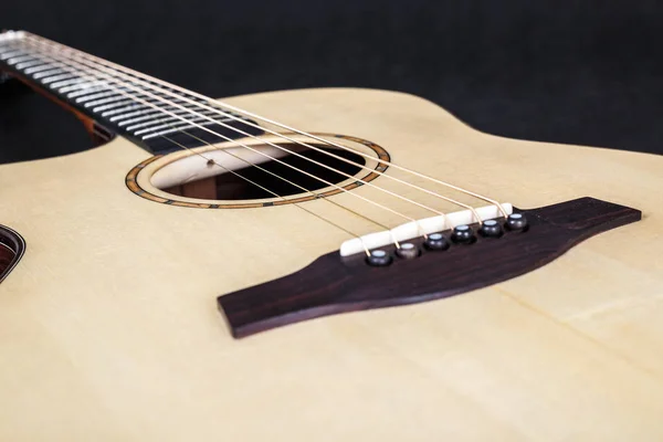 Trä konsistens av nedre däck sex strängar akustisk gitarr på svart bakgrund. gitarr form — Stockfoto