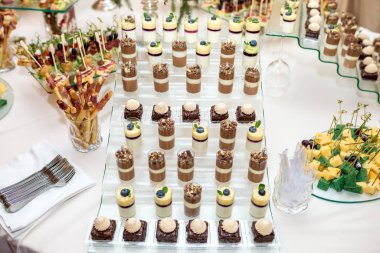 Yemek servisi. Tesis dışı yemek. Çeşitli tatlı çikolatalarla açık büfe masası.
