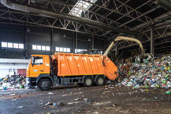 GRODNO, BELARUS -  MAY 2019: truck throws garbage at sorting modern waste recycling processing plant. Separate and sorting garbage collection. Recycling and storage of waste for further disposal. 