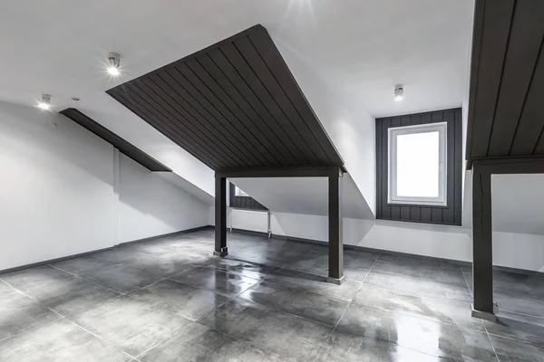 Puste, nieumeblowane mansardowe wnętrze pokoju z drewnianymi kolumnami i mokrą betonową podłogą na poziomie dachu w kolorze czarnym i białym — Zdjęcie stockowe
