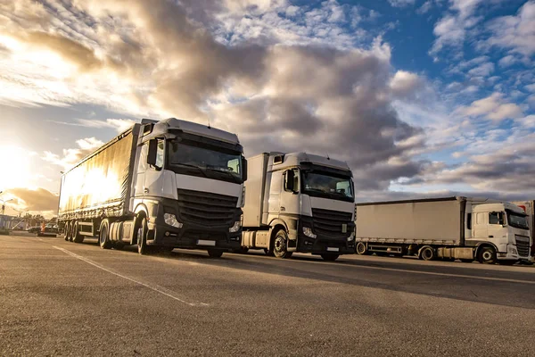Vrachtwagens op een rij met containers op de parkeerplaats. Logistiek en vervoer — Stockfoto