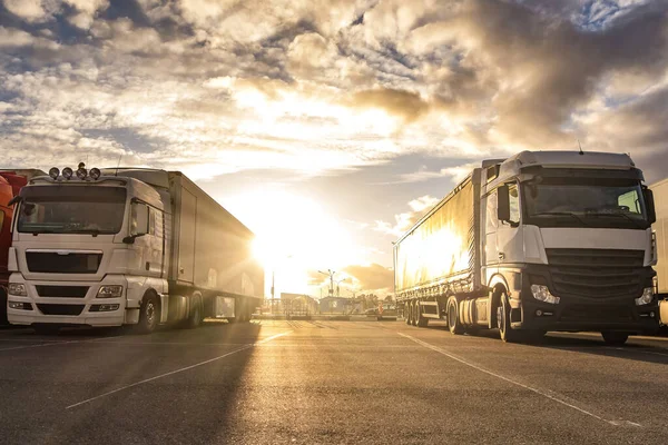 Trucks in a row with containers in the parking lot. Logistic and