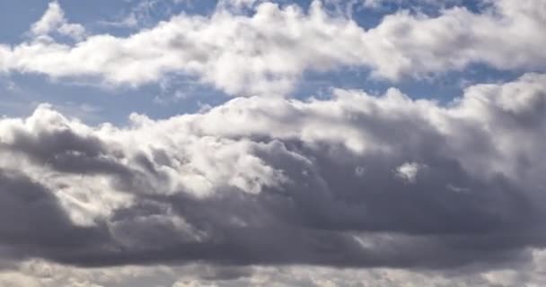 太陽の光で嵐の前の風の強い天候でいくつかのふわふわ圧延雲層の時間経過クリップ — ストック動画