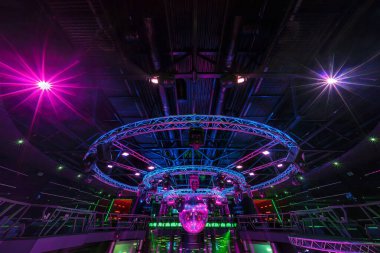 MINSK, BELARUS - MAY 2012: interior of stylish night disco club with neon blue violet light, disco mirror ball and bright floodlight.