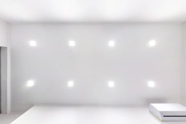 Boş bir odada, dairede ya da evde lambalar ve alçıpan döşemeli asılmış tavan. Gergin tavan beyaz ve karmaşık şekil. Yukarı bakıyorum.