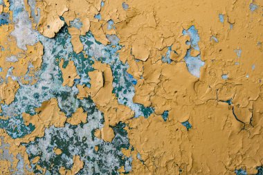 Kırık sarı boya mavi beton duvarda 
