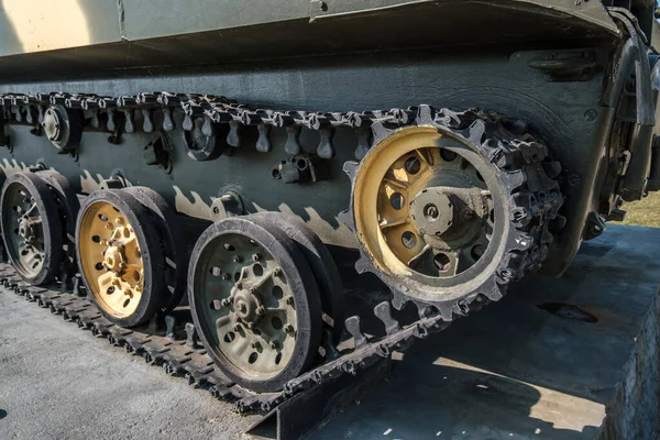 tracks and wheels of tank, armored vehicles on the street in green khaki color
