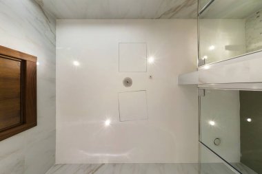 Halojen benekli lambalar ve alçıpan inşaatı ile asılı tavana bak. Daire ya da evdeki boş odada yangın alarmı sensörü var. Gergin tavan beyaz ve karmaşık şekil.