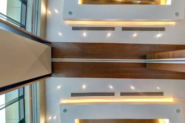 Halojen benekli lambalar ve alçıpan inşaatı ile asılı tavana bak. Daire ya da evdeki boş odada yangın alarmı sensörü var. Gergin tavan beyaz ve karmaşık şekil.