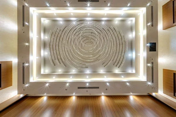 look up on suspended ceiling with halogen spots lamps and drywall construction with fire alarm sensor in empty room in apartment or house. Stretch ceiling