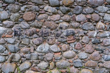 Eski bir duvarın yüzeyi, yıkık dökük bir binanın büyük taşları.