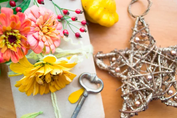 Vecchio libro con zinnia arancione, chiave e frutti di bosco autunnali — Foto Stock