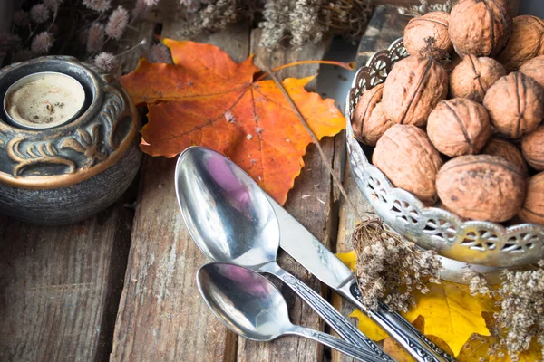 Silberteller mit Walnüssen, Kerze, Herbstblättern und Löffeln — Stockfoto