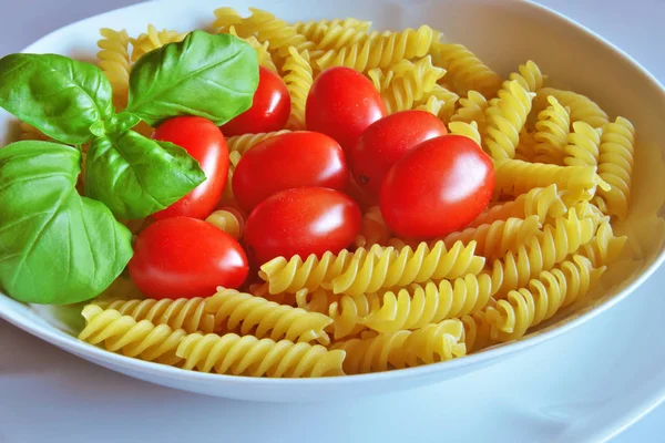 Italská kuchyně. Fusilli s rajčaty a bazalkou — Stock fotografie