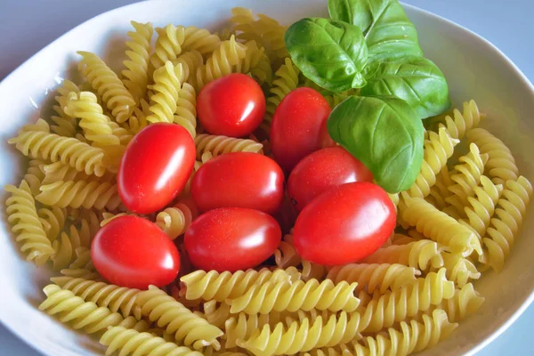 Cozinha italiana. fusilli com tomate e manjericão — Fotografia de Stock