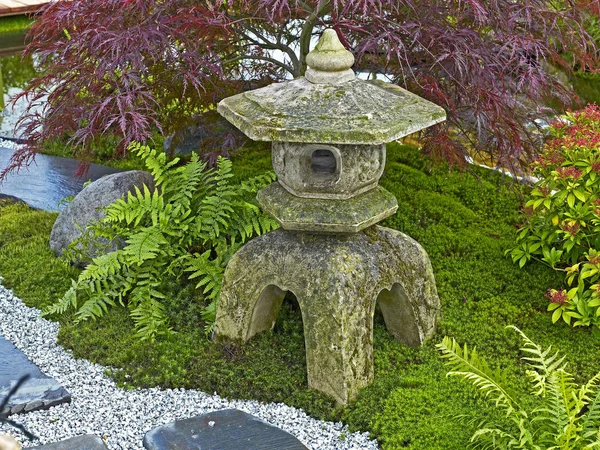 Trädgård i stil med en japansk Tea Garden med traditionell pl plantering och den traditionella Stone Lantern — Stockfoto