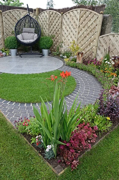 Eine städtische Gartengestaltung, die auf fließenden Kurven um einen Terrassenbereich basiert — Stockfoto