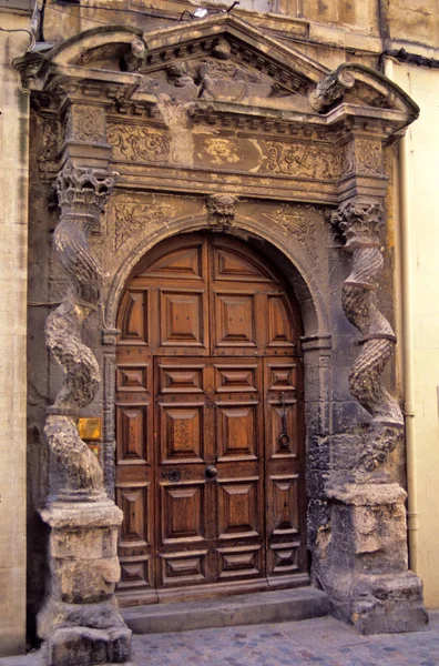 Una antigua puerta de madera decorada con piedra clásica decorativa circundante en Provenza Sur de Francia —  Fotos de Stock