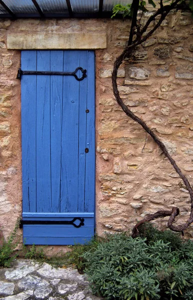 Eine alte bemalte Holztür mit umgebendem Mauerwerk in der Provence — Stockfoto