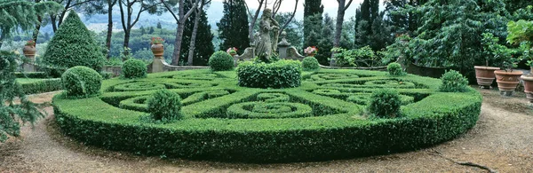 A classical Italian garden in Tuscany with complicated Topiary and a female statue as a panorama