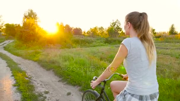 Hermosa joven monta una bicicleta — Vídeos de Stock