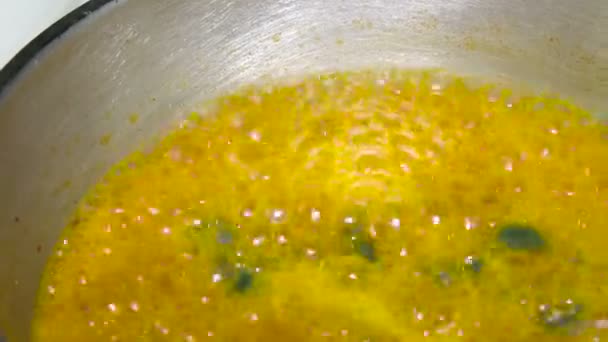 Yellow sauce simmering on the stove. Close up — Stock Video