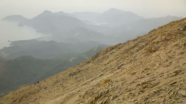 Der Aufstieg auf den Bergrücken. das Meer und die Berge im Nebel — Stockvideo