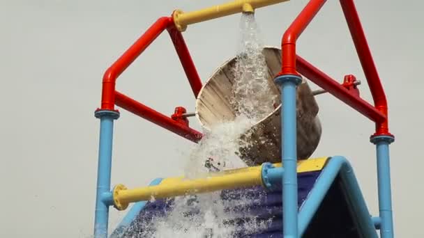 Attractie, water is gegoten uit de emmer in het zwembad — Stockvideo