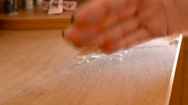 Bir kadının el toz masanın üzerine siliyor.
