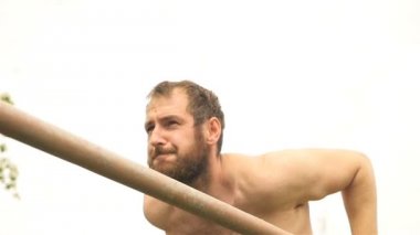 Jimnastik çubuklarında bir adam. Ağır çekim. Sağlıklı bir yaşam tarzı. Açık hava