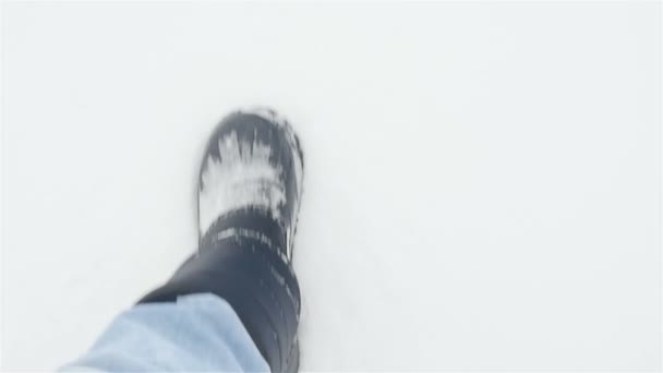 Un hombre camina en la nieve. Primer plano de las piernas. Movimiento lento — Vídeo de stock