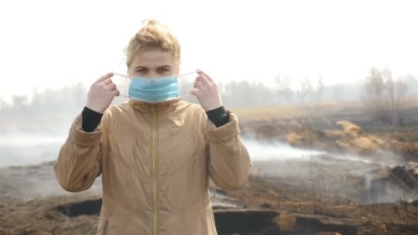 Девушка в медицинской маске. Поле для курения Медленное движение — стоковое видео