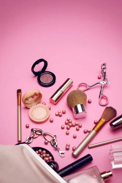 Produtos de maquiagem com saco cosmético e flores no fundo de cor — Fotografia de Stock