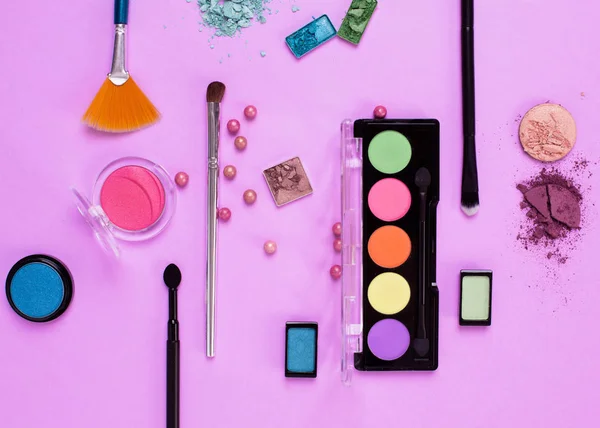 Cosmetici trucco, pennelli e ombre su sfondo rosa. Superiore vi — Foto Stock