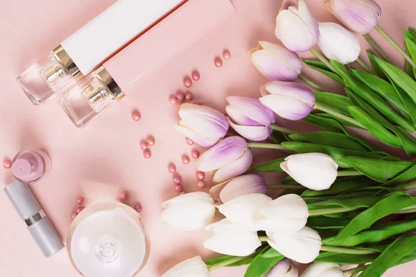 Frascos de perfume rodeado por flores e pérolas em backgro rosa — Fotografia de Stock